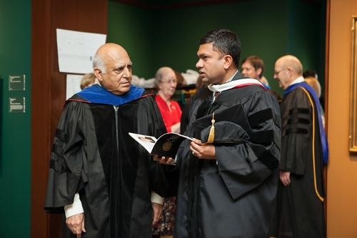 Two faculty members discuss the upcoming ceremony
